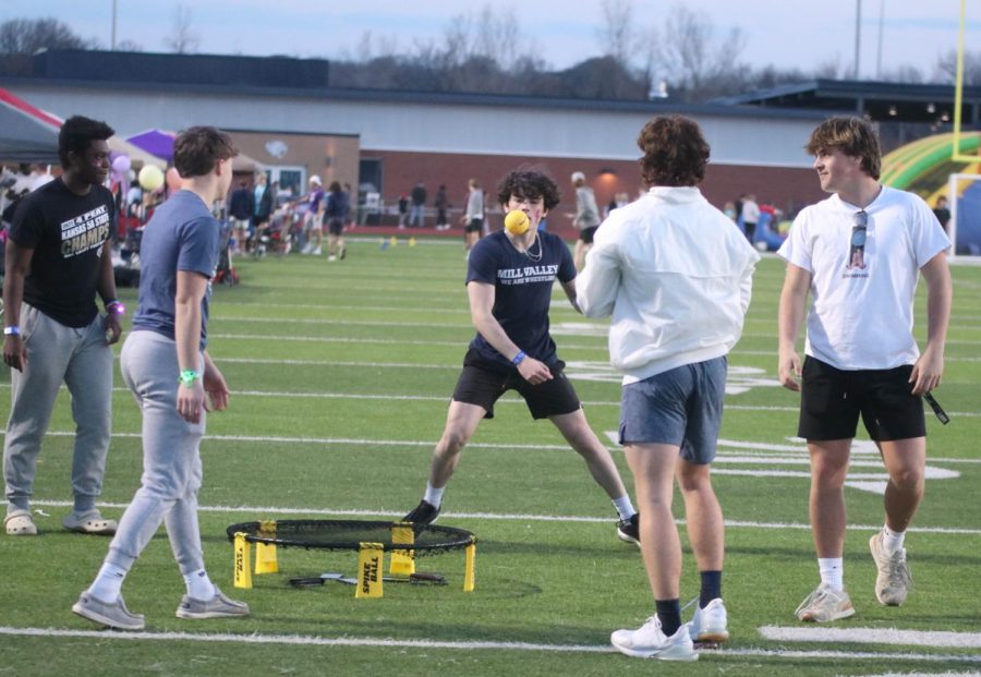 On a break, some of the students play spike ball on the field behind the stands.