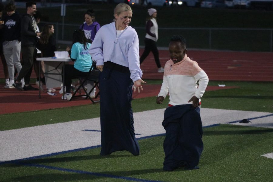 Senior Bri Coup jumps with a boy in a potato sack race.