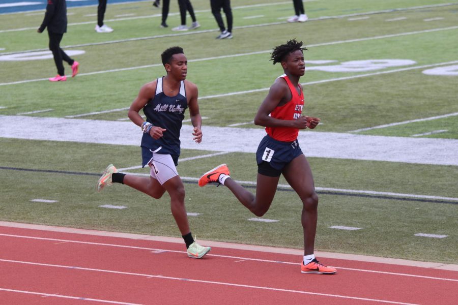 Increasing his pace, junior AJ Vega attempts to pass his Olathe North opponent on the third lap of the 3200 meter race. 