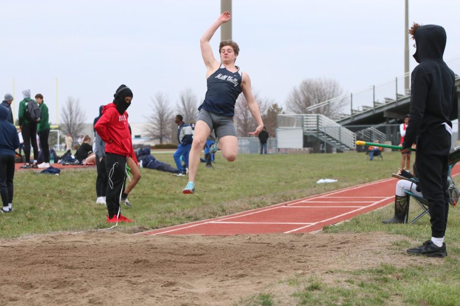 Junior Logan Holdren jumps as far as he can into the long jump pit.