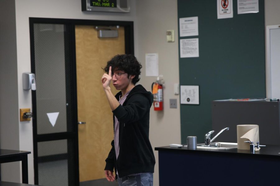 Holding up his finger to an imaginary audience, sophomore Yazid Vazquez practices his performance.
