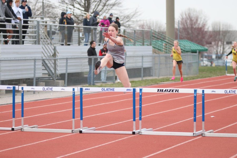 Leaping over the hurdle, sophomore Josie Benson keeps her eyes toward the finish line. Benson took first in the 300 meter hurdles with a time of 50.16 seconds.