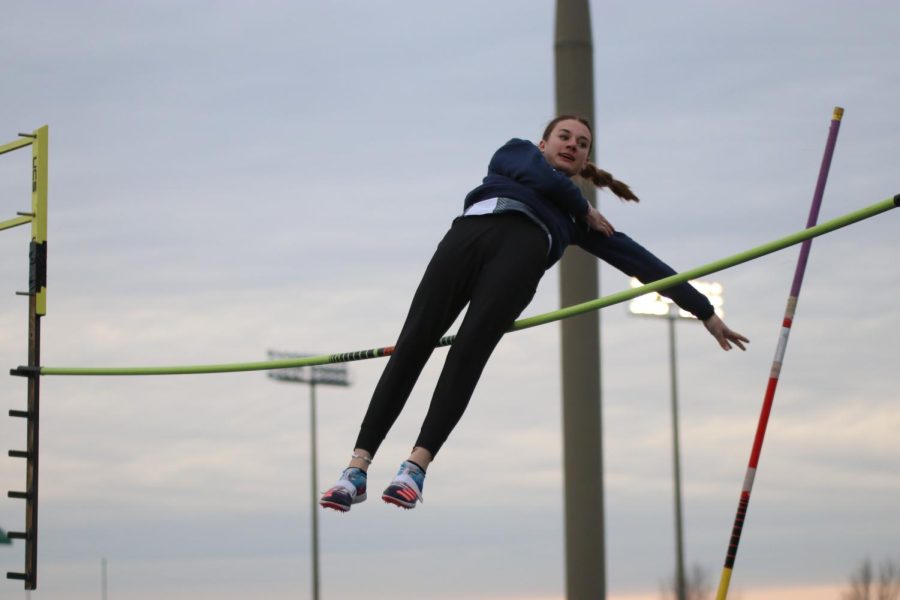 Clearing the bar, sophomore Seville Skinner lets go of her pole to land on the mat.