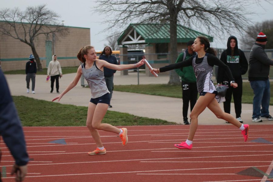 Sophomore Meghan McAfee receives the baton from sophomore Alonnah Gage in the 4x400 meter relay.