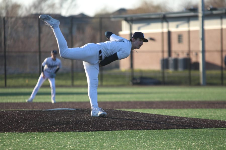 Keeping his eye on the catcher, freshman Beau Peterson throws his pitch.