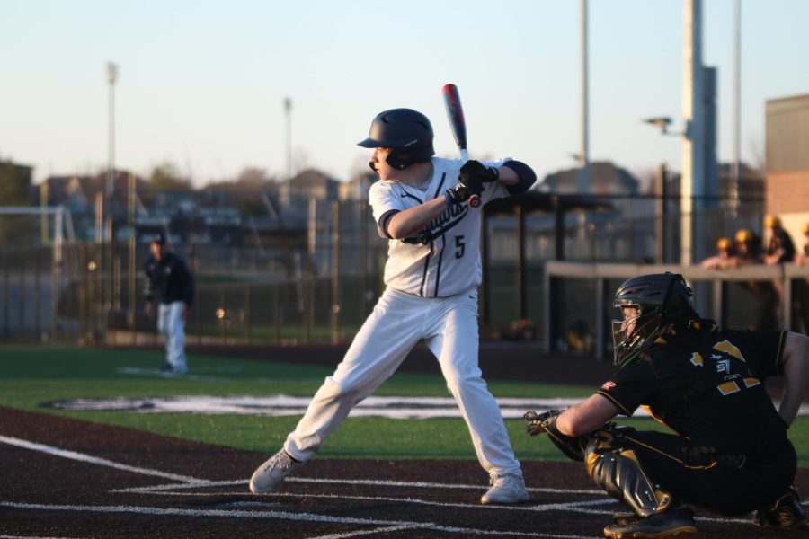 Raising his foot, senior Brant Benson prepares to hit the ball.