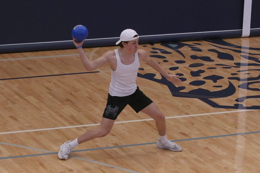 Arm in air, freshman Gavin Hurt throws the dodgeball at an opposing team member.