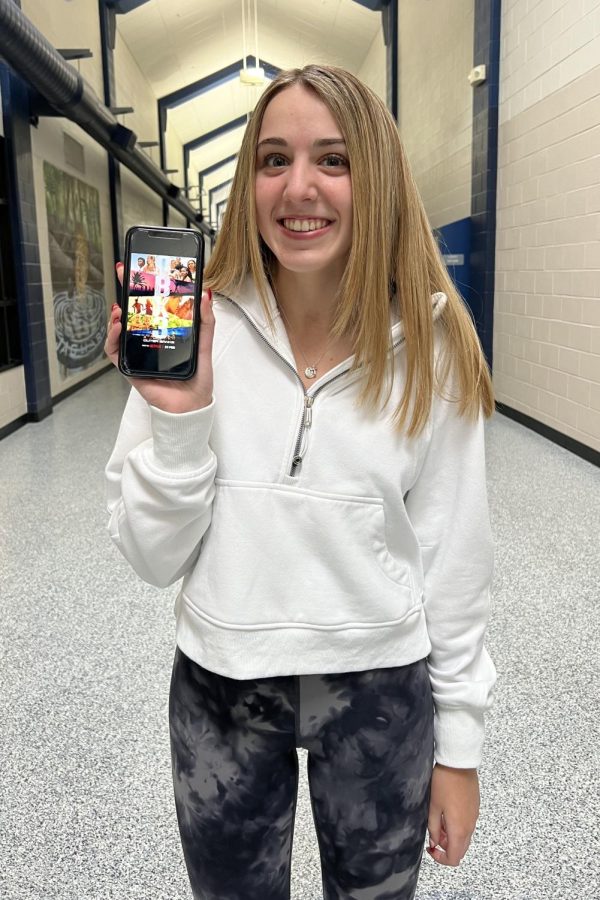 Junior Reagan Roberts holds her phone up to the camera to show her favorite TV show, Outer Banks.