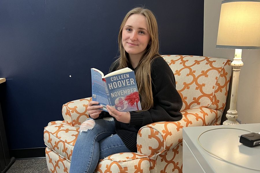 Ready to curl up over Spring break and read, senior Jayda DeWitte poses holding her new book November 9 by Colleen Hoover.
