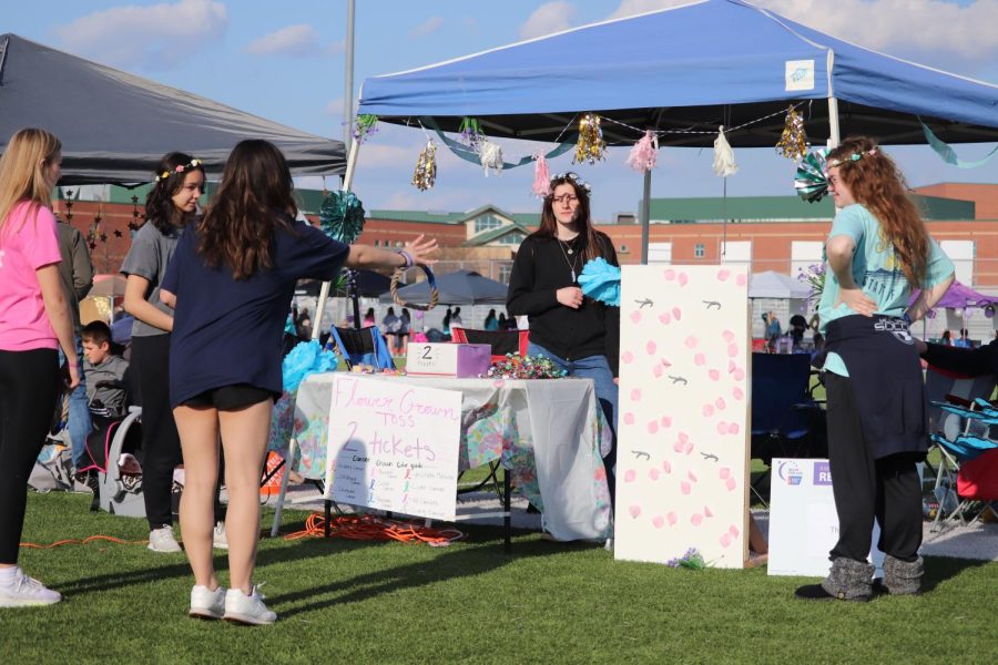 A student tosses a ring toward the board in an attempt to win herself a flower crown.