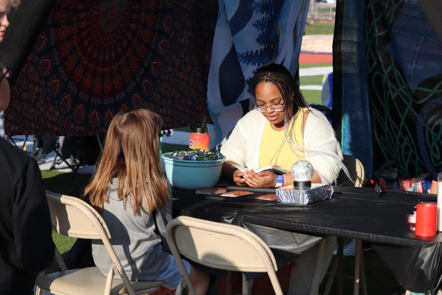 Sophomore Autumn Graves tells a participant’s fortunes at her Relay for Life booth.  