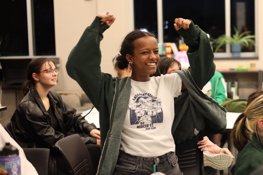 Putting her arms in the air, junior Meron Abebe smiles as she celebrates getting the trivia question right Friday, March 10


