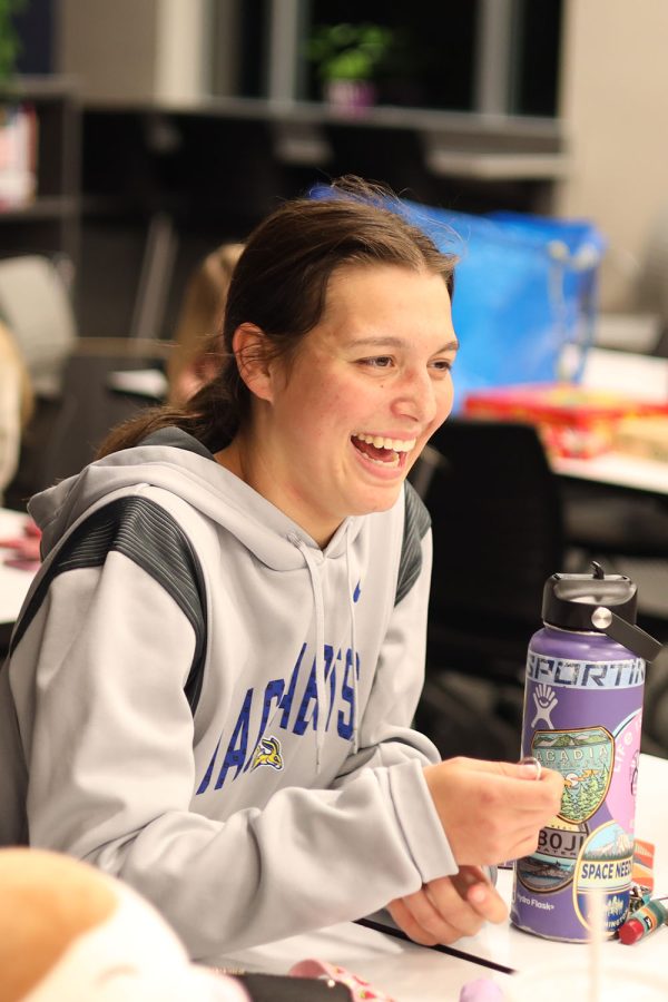 Listening to the debate of the possible answers, junior Shelby Kindt laughs at her teammates. 
