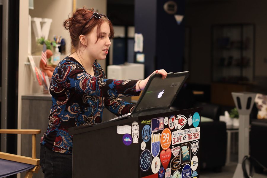 Standing in front of the group, club president Gwen Heideman explains how the round of trivia will work. 
