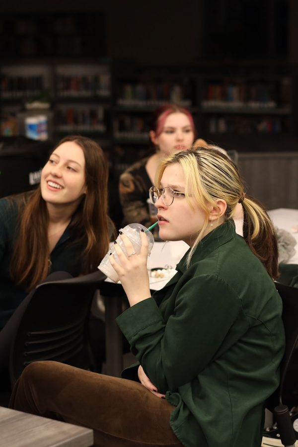 Sipping her drink, junior Kaelyn Russell reads the question on the board. 
