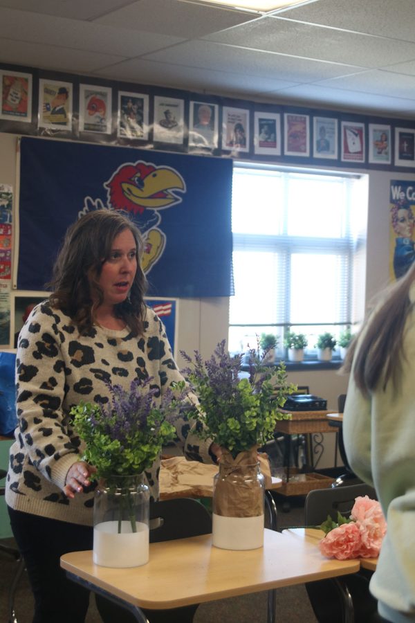Prom committee leader social studies teacher Angie DalBello discusses with the prom committee how to fill empty space in the decorative vases. 