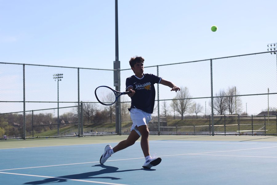 Junior Liam Watson strides up the court to strike the ball back to his opponent.