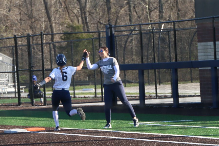 After batting, sophomore Ashley Bryant high-fives assistant coach Ariel as she nears first base. 
