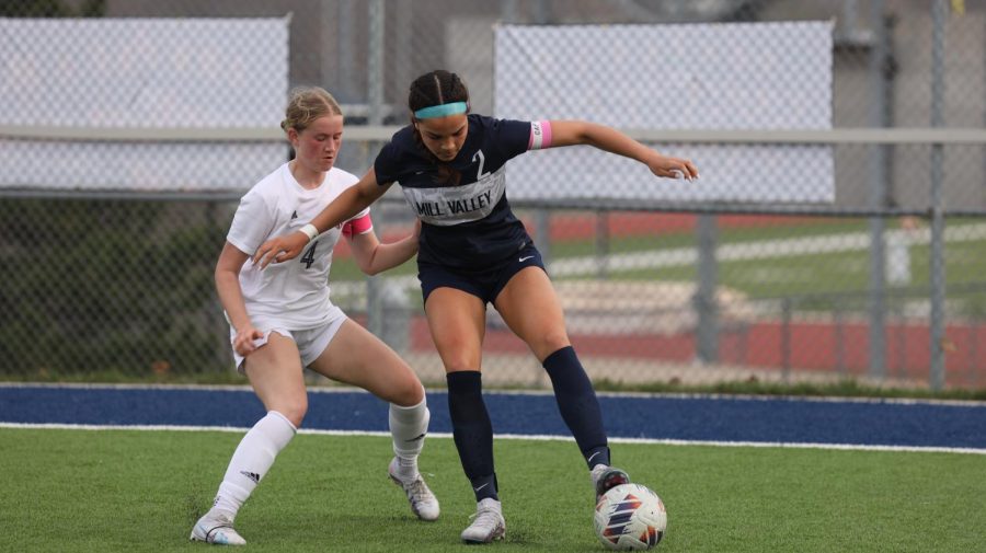 Senior Olivia Page uses her body to protect the ball from the defender. 