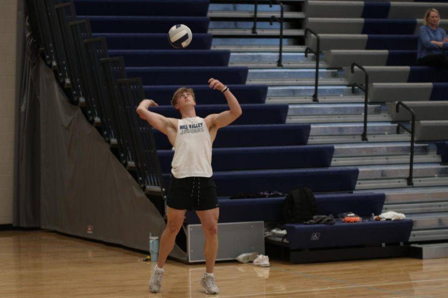 Throwing the ball in the air, senior Hayden Jay serves the ball over the net to the other team.