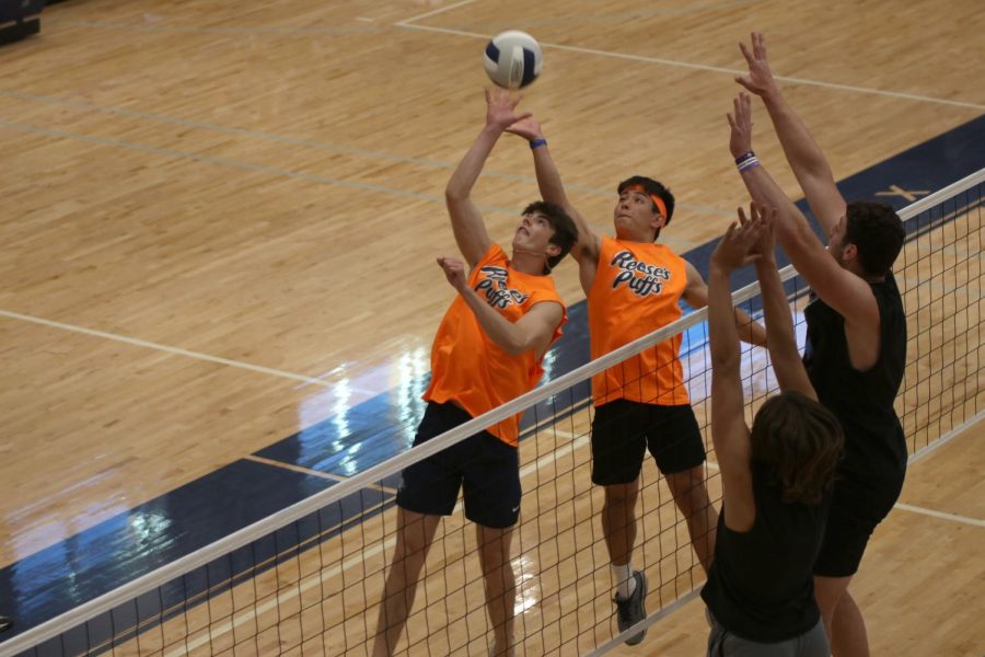 Juniors Kenten Laughmen and Walt Midyett hit the ball over the net, as Juniors Sully Suderman and Gus Hawkins attempt to block it.