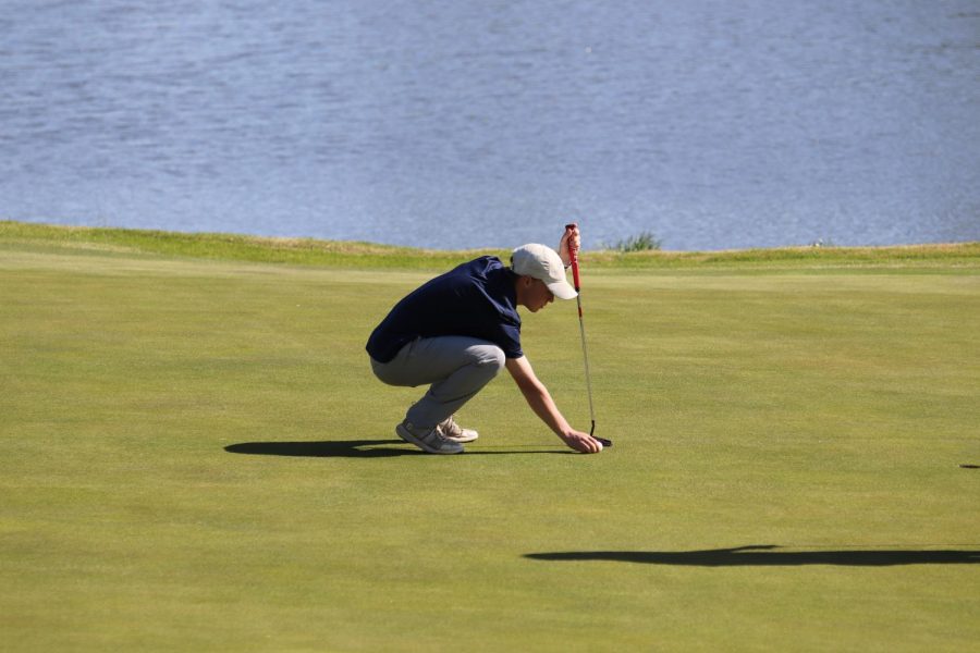 On the green, senior Matt Morgan places his ball. 