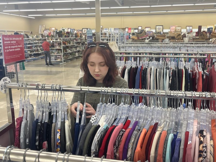 Scanning the clothing rack at Savers thrift store, junior Gwen Heideman looks through the women’s clothes Monday, April 10. Heidman shops at thrift stores because she thinks it’s better for the environment and she can also find more unique pieces of clothing.