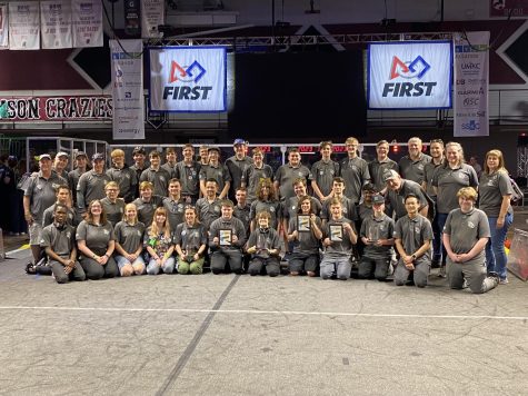 Holding their awards, members of both the JV and Varsity FIRST robotics teams, Cub-atronics and Catatronics, smile for the camera on the game field Saturday, April 1