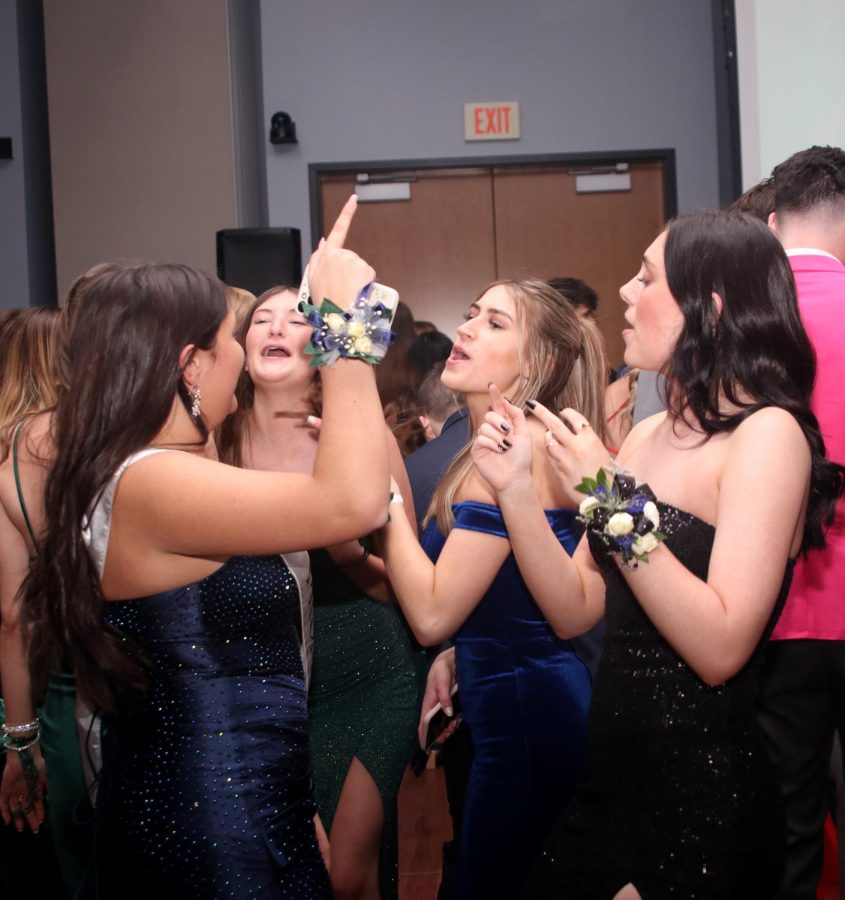 Singing along with friends, senior Hayden Rider points in the air.