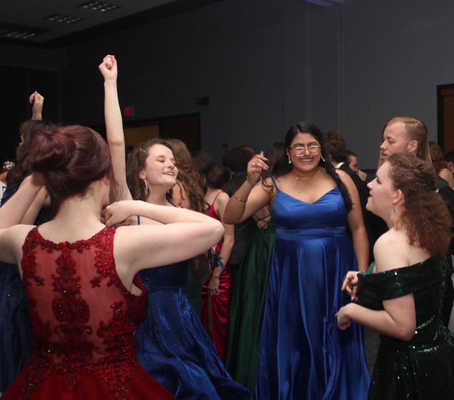 With her hand up, senior Mallory Botts dances with friends.