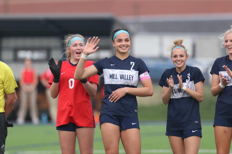 During the the game's starting lineup, senior Olivia Page waves to the crowd as she is introduced as a team captain.