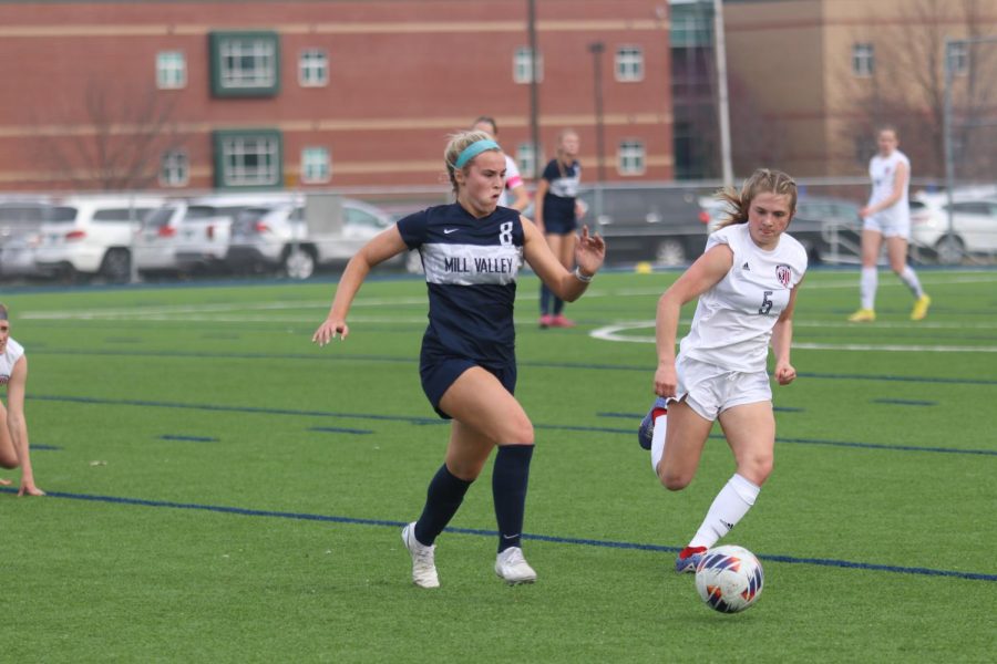 Junior Kate Ricker races against an Olathe North midfielder to gain possession of the ball.
