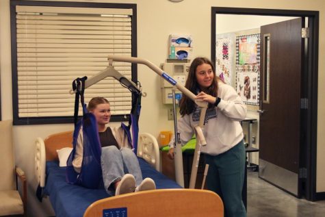 During the Health Careers class at Eudora, junior Jenna Graber is being lifted up from a patient care bed by junior Elle Vanrheen to practice moving patients from place to place Wednesday, April 5.