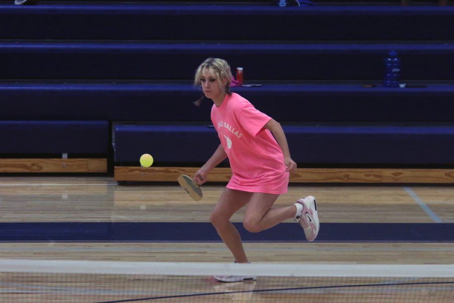 Running to the side, freshman Heidi Baillos tries to hit the ball.