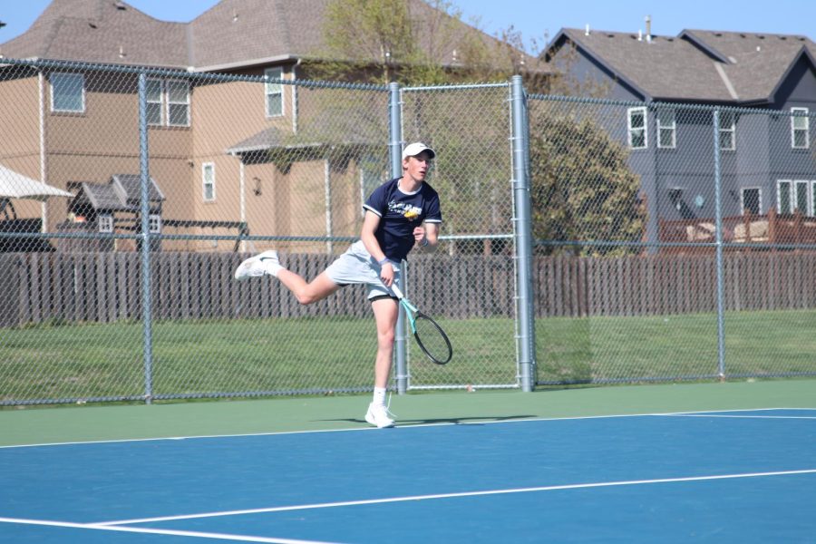 Landing on his foot, sophomore Cole Huffman finishes his serve.
