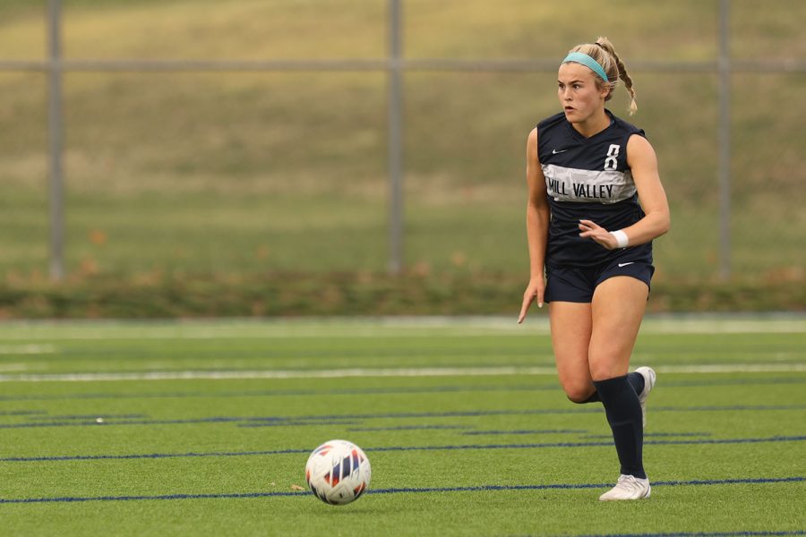 Looking for her next pass, Junior Kate Ricker dribbles down the field with the ball.  