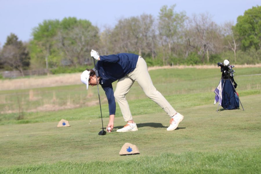 Setting up for his next swing, junior Broden Resch puts the ball on the tee.
