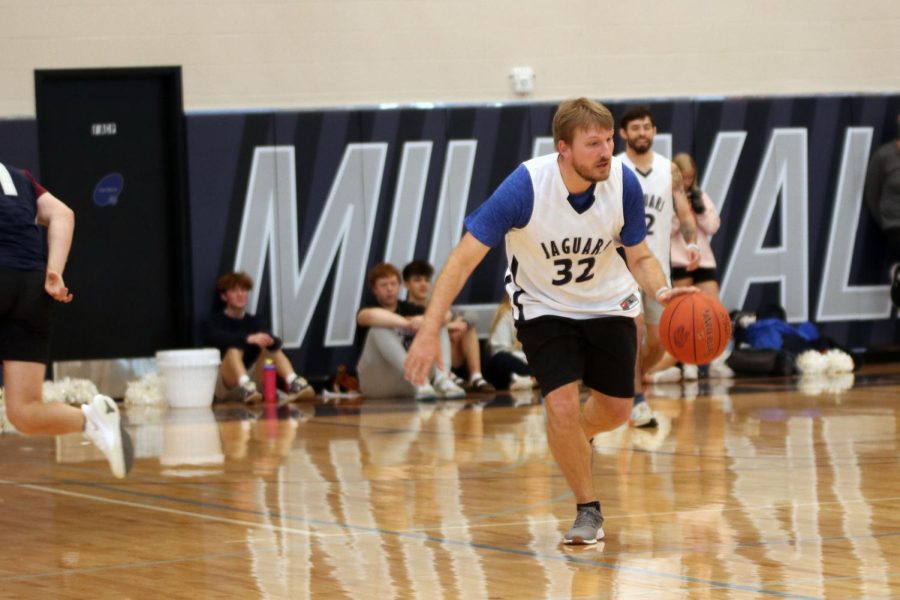 During the teachers vs. students basketball game, graphic design teacher Mr. Kohler dribbles the ball down the court. 