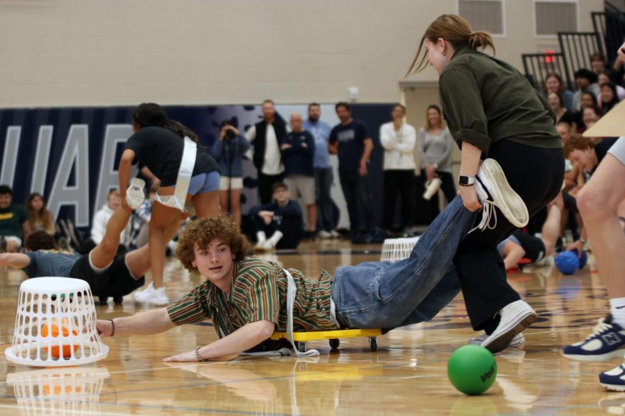 Seniors Finn Campbell and Asa Esparza collect dodgeballs in the prom candidate game “Hungry Hungry Hippos”.