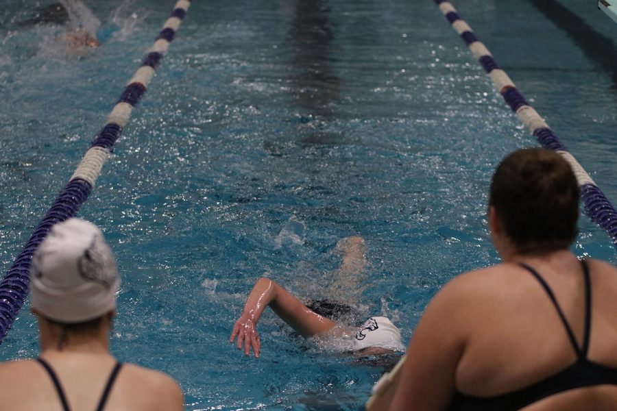 Being supportive of their teammates, junior Kate Haney and a fellow team member help cheer a student on.  