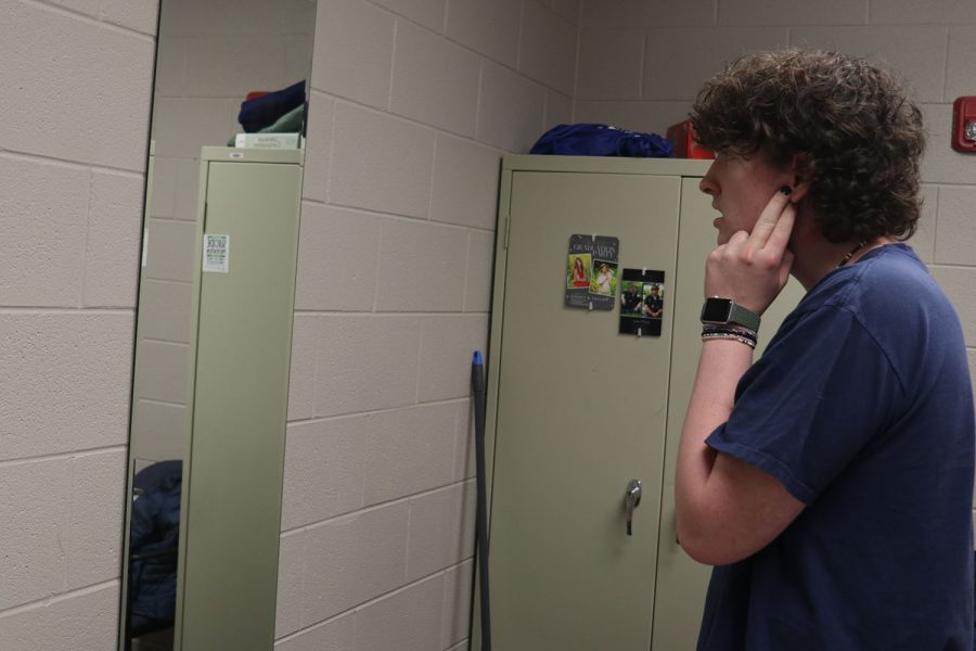 Looking at himself in the mirror, sophomore Blake Gray sings his regionals solo in an empty practice room. 