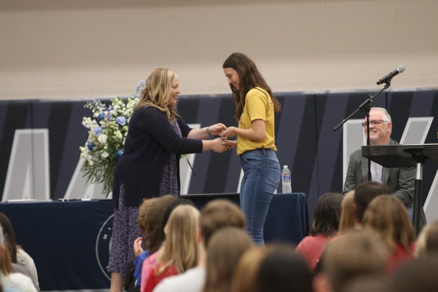 Shaking counselor Megan Mixon’s hand, senior Makenna Arnold receives her silver presidents volunteer service award medal.