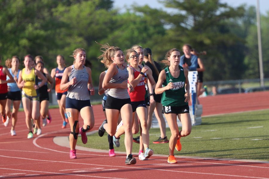 Staying with the pack, junior Kynley Verdict sets the pace for junior Sarah Anderson during the 1600 meter.