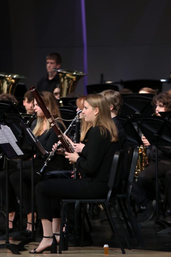 Sitting with other members of the band, junior Kate Marten plays the bassoon. 