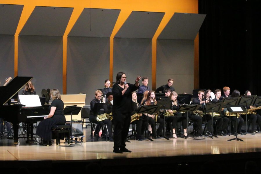 Microphone in hand, band director Deb Steiner welcomes the audience to the annual spring band concert. 