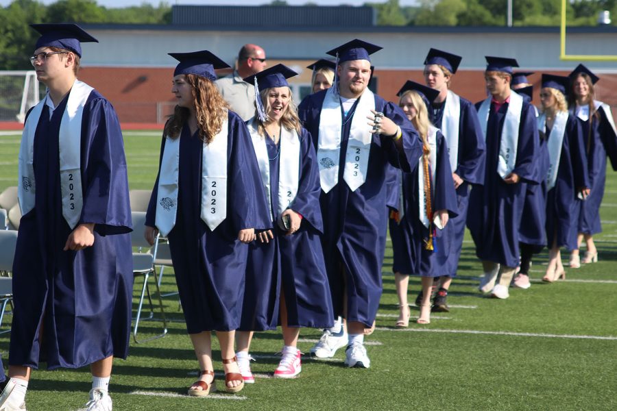 Before taking their seats, seniors Bella Mehner and Jack Melvin pose for a picture holding out a four to show off his rings.