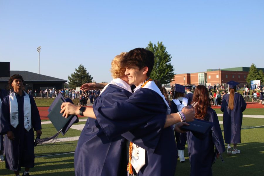 Smiling, seniors Mikey Bergeron and Lucas Robins congratulate each other with a hug.
