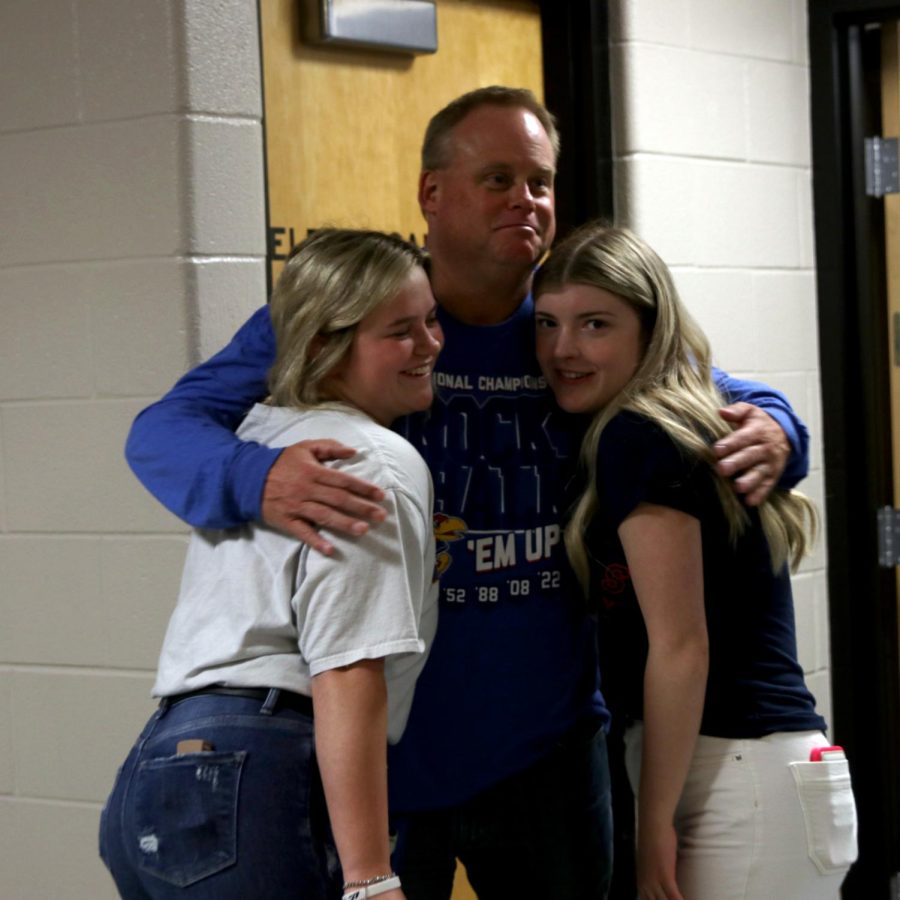 Seniors Jenna Myres and Mary Caroline Graves hug math teacher Kevin Mosher. 
