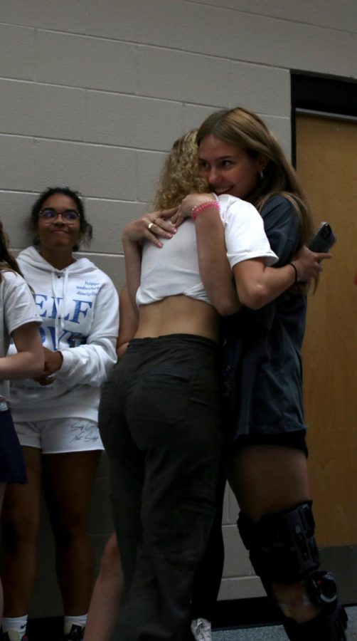 During the last walk through, senior Taylor Modrcin hugs junior Abby Wolff.