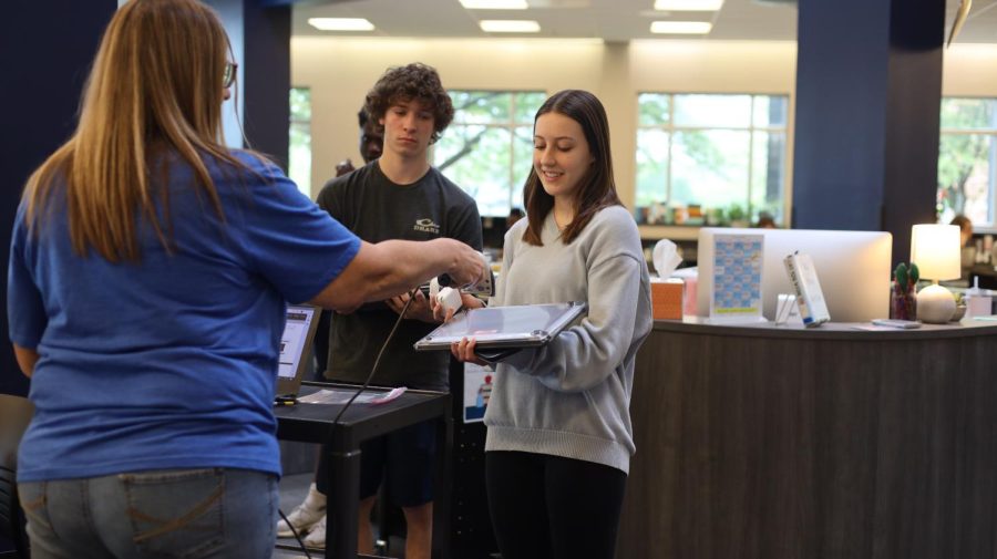 Junior Christy Atkinson gets her new laptop checked out in the media center Thursday, April 20.